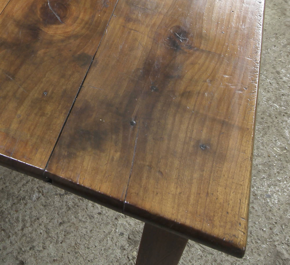 French farmhouse table close up showing detail of the top and the wood grain