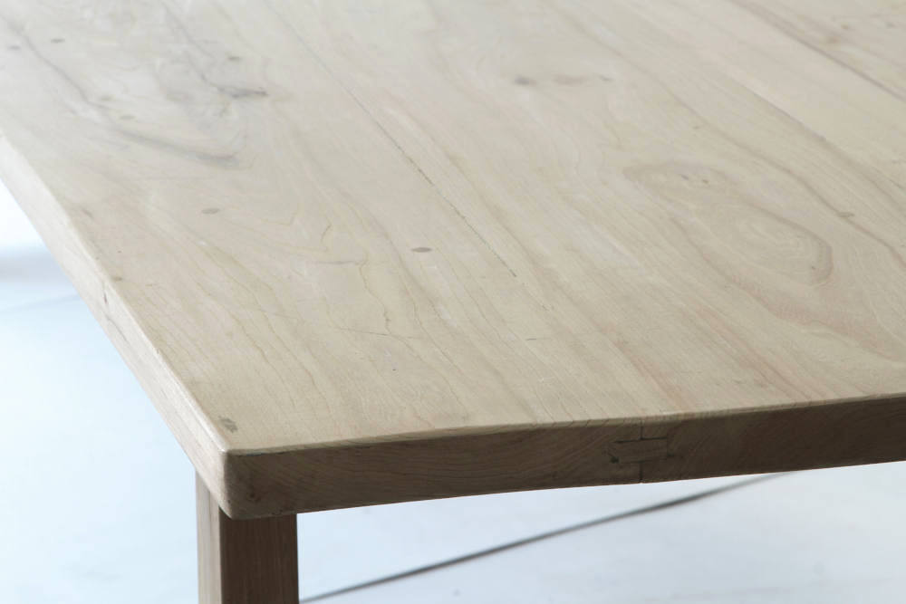 A corner view image of the Normandy elm top table showing the wood grain