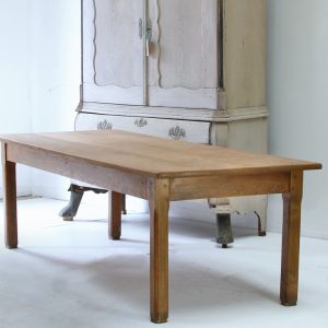 A French farmhouse table in elm featuring a generous three plank top