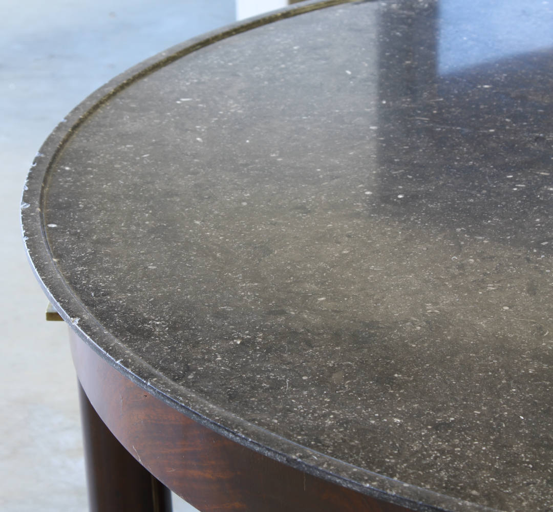 A close up view of the marble top on an empire gueridon table